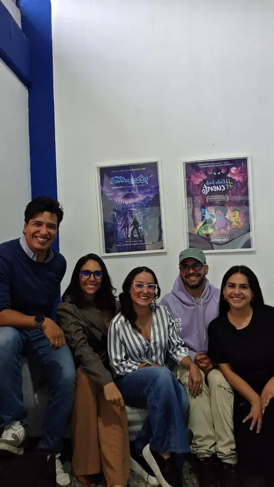 Parte del equipo de Criter Studio frente a los afiches de sus series