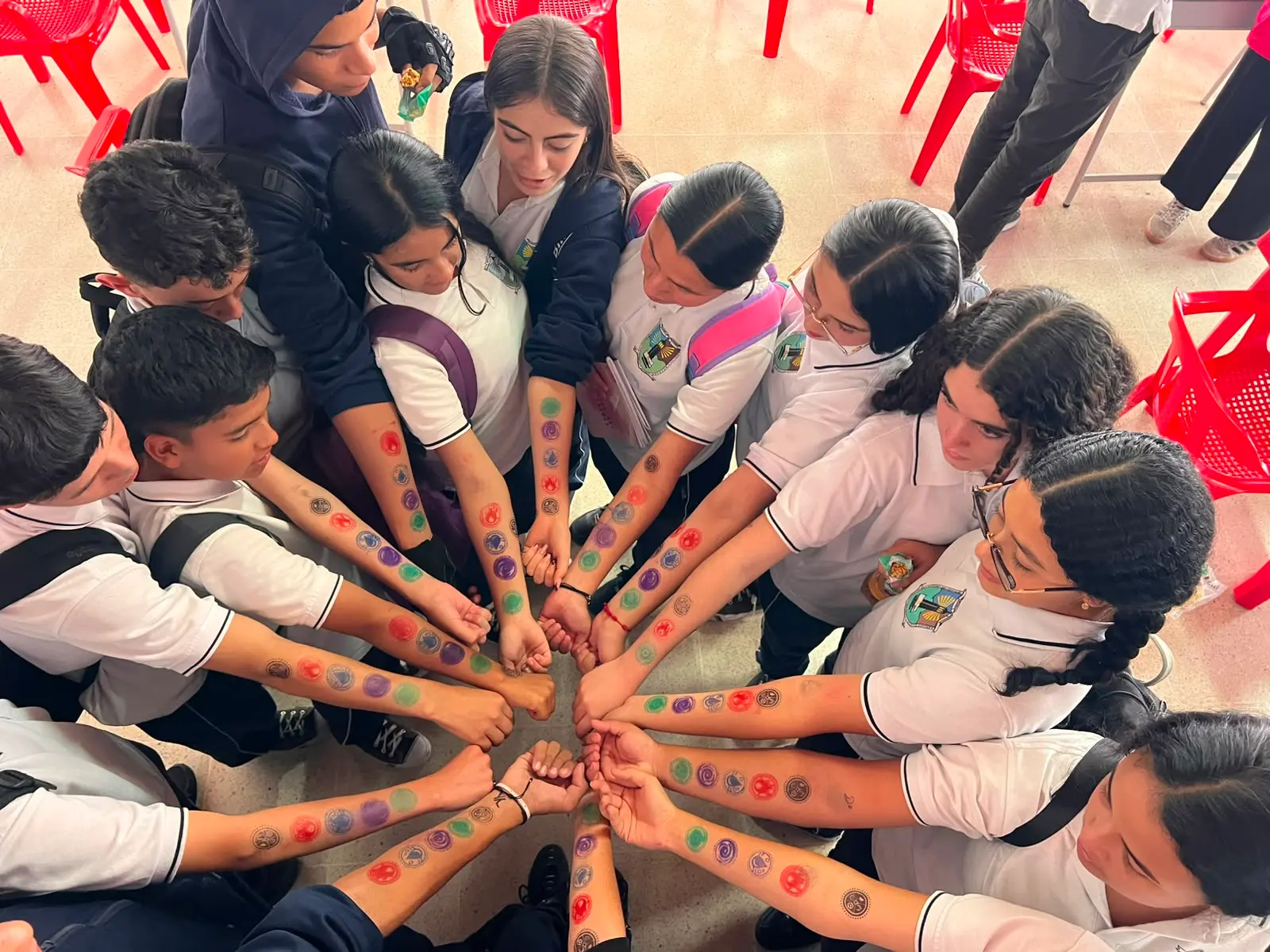 Manos de estudiantes unidas en círculo
